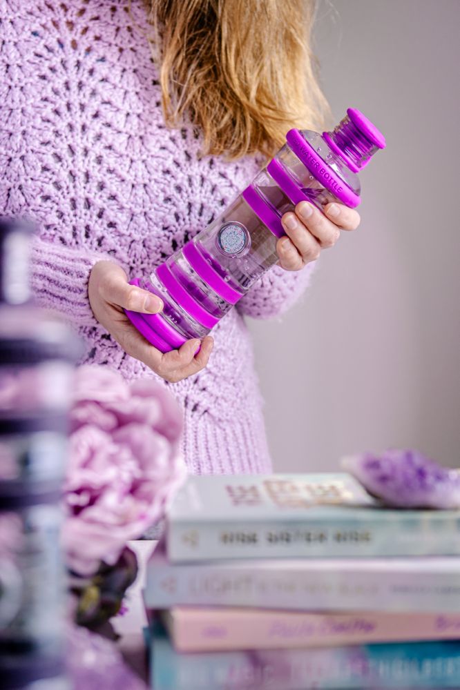 Eco-friendly i9 violet water bottle with information tag, held by woman in purple sweater